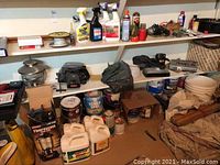 Photo showing shelves with various paint cans, garden chemicals, and tools including power tools and hand tools.
