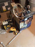 Overview of all items: PT2000 paint roller system, Wagner wide shot pro sprayer, and two-step ladder, all on floor with visible paint stains.