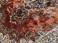 Close-up of rust-red silk pile and floral motif