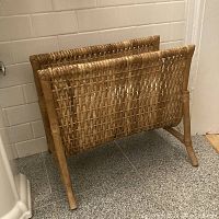 Front and side angled view of vintage rattan and wicker floor stand showing woven panel structure and four splayed legs