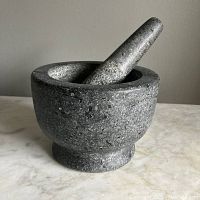 Granite mortar and pestle assembled, showing side view and texture.