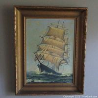 Frontal view of framed oil painting of a sailing ship