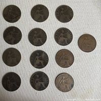 Coins arranged front side with seated Britannia design, showing reverse side of Victorian pennies and half pennies.