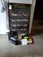 Framed wine-themed picture, two bottle bags, folded bar towel, two sets of coasters, and a green fabric item arranged on floor