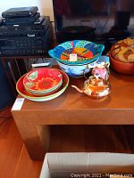 Display table with synthetic ostrich leather upholstery, decorated with various ceramic and metal kitchenware items (not included in sale).