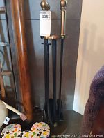 Full view of the fireplace tool set including stand and tools hanging