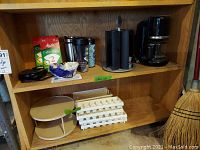 Shelving with KitchenAid coffee maker, Mr. Coffee cup heater, travel mugs, Melitta coffee filters, lazy Susan stand, and egg trays
