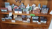 Photo showing multiple hand-painted Cat's Meow Artisan landmark woodblocks on shelves with visible cat silhouettes on each block.