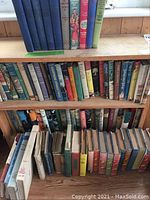 Bookshelves displaying a large collection of vintage and nostalgic children's books in various colored hardcovers, some with illustrated spines.