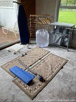 General overview of lot showing ironing board, drying rack, hangers, laundry sorter and rug runners