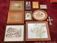 Overview of all framed wall art laid out on floor showing variety including botanical prints, architectural drawing, birds chart and cross.