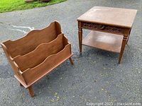 Wood magazine rack with two compartments and scalloped top on asphalt surface