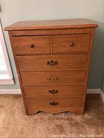 Front view showing five drawers with two different types of handles and visible surface wear.