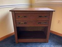 Front view of the vintage solid wood dresser showing two drawers with metal handles and open base without lower cabinet doors.