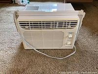 Front view of Haier window AC showing vents and two control dials for mode and temperature.