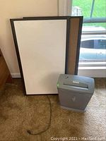 Two framed boards standing upright, one whiteboard and one corkboard, both with black frames.