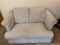 Front view of twin size sleeper sofa with grey and cream vertical stripes and two back cushions.