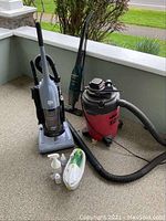 Wide view showing all vacuums and accessories on porch