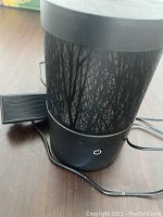 Top down and front side view of the Scentsy Go diffuser, showing its rose gold color, power button, and decorative cutout pattern.