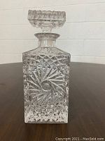 Front and side views of the first square crystal decanter with spiral and diamond cut patterns, showing faceted stopper.