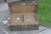 Open military trunk with removable interior tray visible, showing two compartments inside.