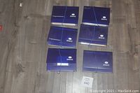 Photo of all six Creative Memories purple accordion folders arranged on floor with elastic bands securing them, showing label slots and varying thicknesses.