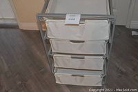 Front view of the cart showing four cloth drawers and metal frame, placed on wood floor.