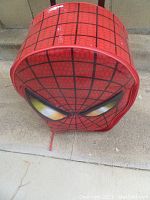 Close-up of front rounded side of the Spiderman kids suitcase showing spider web pattern and eyes.