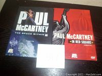 Two Paul McCartney concert film DVDs 'The Space Within Us' and 'In Red Square' side by side on a surface.