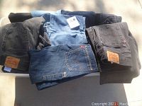 Top view of bucket showing folded jeans and pants in blue and black denim with Levi's labels visible