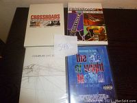 Four concert CDs/DVDs displayed on a flat surface with a note showing the lot number 548. Includes The Isle of Wight Festival, Coldplay Live 2003, and two Eric Clapton Crossroads Guitar Festival editions.