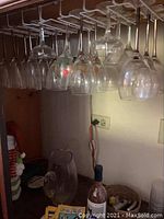 Hanging assortment of wine and champagne glasses from rack, showing size and variety.