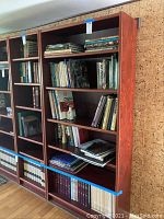 Front view of bookshelf filled with books, showing overall size and condition.