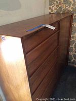 Front view of the wood cabinet showing drawers and wood finish