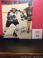 Full view of the autographed photo showing both players and signature.