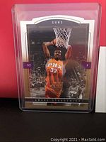 Front side of Amare Stoudemire gold proof basketball card in protective case showing him dunking with Phoenix Suns orange jersey number 32.
