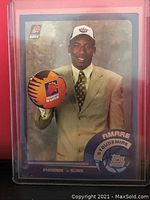Amare Stoudemire rookie card in plastic protective holder with clear view of player in suit holding Suns basketball.