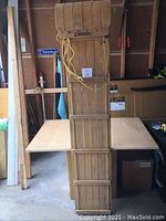 Toboggan standing upright against a table in a garage or storage space, showing front curve and Chinook brand.