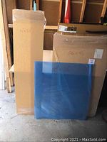 Three plexiglass sheets standing upright with cardboard backing, dimensions written on packing: 14x54, 26x45 inches.