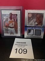 Photo of Gilbert Arenas and Devin Harris rookie basketball cards in protective sleeves with auction lot label.