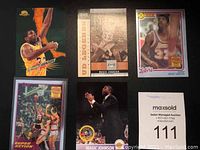 Five Magic Johnson basketball cards displayed together, showing front designs
