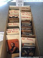 Two cardboard bins filled with sorted basketball trading cards by player labels.