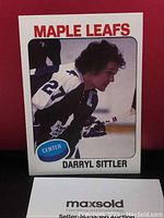 Front view of Darryl Sittler hockey card, side profile portrait in Maple Leafs white jersey number 27 with blue center designation.