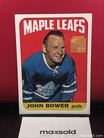 Front of Johnny Bower hockey card showing Maple Leafs logo and player in blue jersey