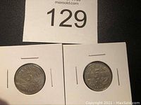 Two Canadian five cent coins dated 1922 and 1923 in coin holders.