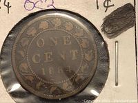 Close-up image showing the inscription 'ONE CENT 1884' surrounded by a wreath design on the old Canadian penny.