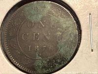 Close-up of one side of the coin showing the inscription 'ONE CENT 1876' and areas of green corrosion.