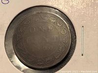 Close-up photo of the large penny coin showing the inscription 'ONE CENT' and part of the decorative border.