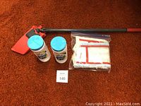 Photo showing the Vileda mop with red mop head, two Glade Carpet & Rug Fresh containers, and two mop heads in plastic packaging on an orange carpeted floor.