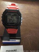 Casio digital watch displayed upright on its original box with maxsold card visible